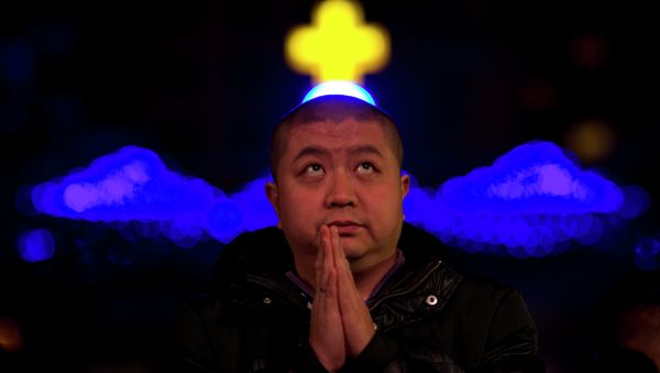 A Chinese man prays during a mass on the eve of Christmas at the South Cathedral official Catholic church in Beijing, China A Chinese man prays during a mass on the eve of Christmas at the South Cathedral official Catholic church in Beijing, China - Sputnik International