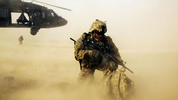 A U.S. soldier from the 3rd Cavalry Regiment shields himself from the rotor wash of a UH-60 Blackhawk helicopter after being dropped off for a mission with the Afghan police near Jalalabad - Sputnik International