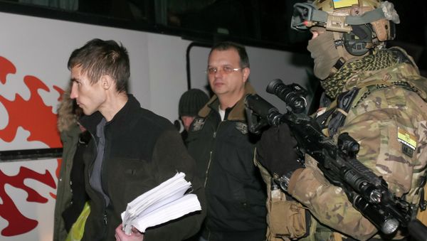 Members of pro-Russian rebels walk past a Ukrainian serviceman during an exchange of prisoners of war outside Donetsk Members of pro-Russian rebels walk past a Ukrainian serviceman during an exchange of prisoners of war outside Donetsk - Sputnik International