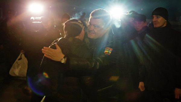 Ukraine's President Petro Poroshenko (C) greets a Ukrainian prisoner-of-war returning home after being exchanged for independence supporters, in Kiev. Ukraine's President Petro Poroshenko (C) greets a Ukrainian prisoner-of-war returning home after being exchanged for independence supporters, in Kiev. - Sputnik International
