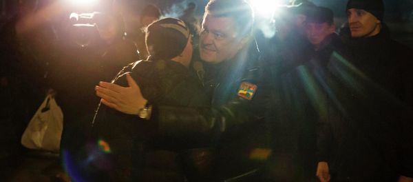 Ukraine's President Petro Poroshenko (C) greets a Ukrainian prisoner-of-war returning home after being exchanged for independence supporters, in Kiev. Ukraine's President Petro Poroshenko (C) greets a Ukrainian prisoner-of-war returning home after being exchanged for independence supporters, in Kiev. - Sputnik International