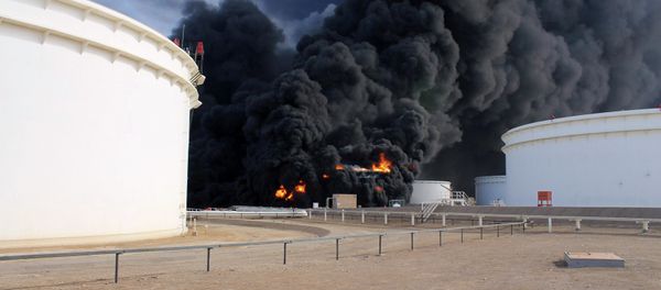 Smoke rises from an oil tank fire in Es Sider port December 26, 2014. A fire at an oil storage tank at Libya's Es Sider port has spread to two more tanks after a rocket hit the country's biggest terminal during clashes between forces allied to competing governments, officials said on Friday. Smoke rises from an oil tank fire in Es Sider port December 26, 2014. A fire at an oil storage tank at Libya's Es Sider port has spread to two more tanks after a rocket hit the country's biggest terminal during clashes between forces allied to competing governments, officials said on Friday. - Sputnik International