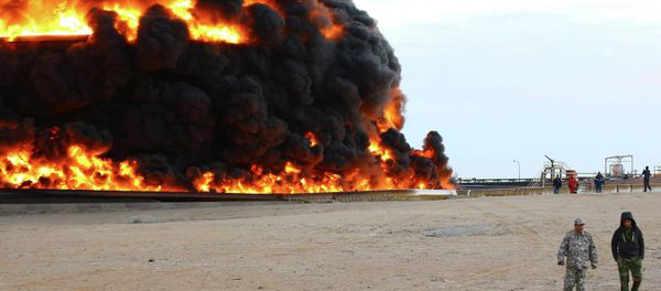Firefighters try to put out the fire in an oil tank in Es Sider port December 26, 2014 - Sputnik International