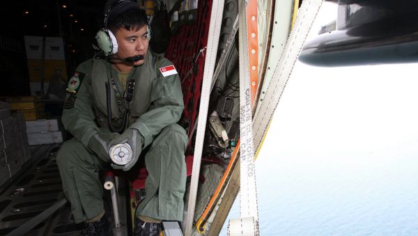 A member of the Republic of Singapore Air Force (RSAF) looks out into the waters, onboard a C-130 Hercules, during a Search and Locate operation for the missing AirAsia QZ8501 aircraft over an undisclosed search area December 29, 2014 A member of the Republic of Singapore Air Force (RSAF) looks out into the waters, onboard a C-130 Hercules, during a Search and Locate operation for the missing AirAsia QZ8501 aircraft over an undisclosed search area December 29, 2014 - Sputnik International