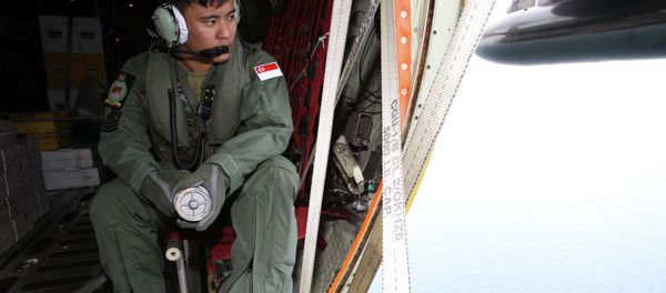 A member of the Republic of Singapore Air Force (RSAF) looks out into the waters, onboard a C-130 Hercules, during a Search and Locate operation for the missing AirAsia QZ8501 aircraft over an undisclosed search area December 29, 2014 A member of the Republic of Singapore Air Force (RSAF) looks out into the waters, onboard a C-130 Hercules, during a Search and Locate operation for the missing AirAsia QZ8501 aircraft over an undisclosed search area December 29, 2014 - Sputnik International