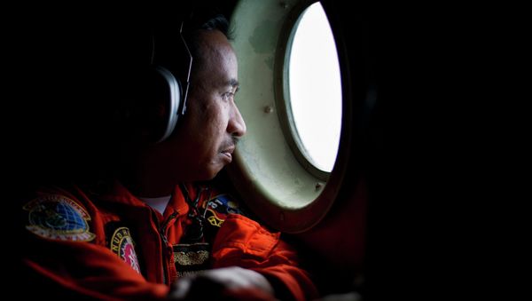 A member of an Indonesian Hercules C130 aircrew watches through a window while monitoring the Belitung Timur sea during search operations for AirAsia flight QZ8501 near Belitung island, December 29, 2014 A member of an Indonesian Hercules C130 aircrew watches through a window while monitoring the Belitung Timur sea during search operations for AirAsia flight QZ8501 near Belitung island, December 29, 2014 - Sputnik International