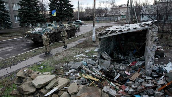 Ukrainian servicemen stand near a building damaged during fighting between militia and Ukrainian government forces in the eastern Ukrainian town of Debaltseve in Donetsk region, December 24, 2014 - Sputnik International