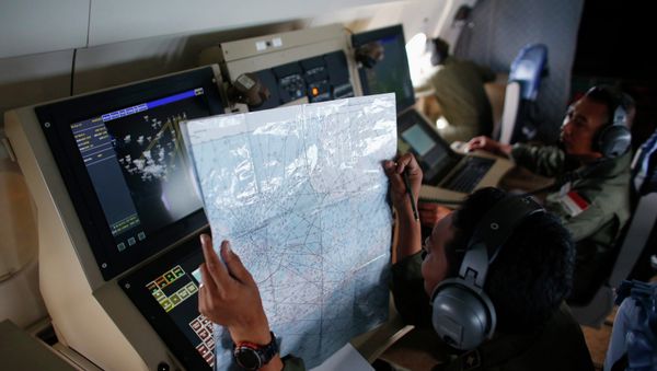 A crew member on an Indonesian Maritime Surveillance plane checks a map during a search for AirAsia's Flight QZ8501 north of Bangka island December 30, 2014 A crew member on an Indonesian Maritime Surveillance plane checks a map during a search for AirAsia's Flight QZ8501 north of Bangka island December 30, 2014 - Sputnik International