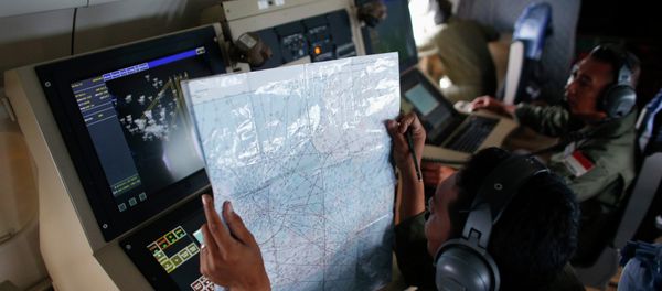 A crew member on an Indonesian Maritime Surveillance plane checks a map during a search for AirAsia's Flight QZ8501 north of Bangka island December 30, 2014 A crew member on an Indonesian Maritime Surveillance plane checks a map during a search for AirAsia's Flight QZ8501 north of Bangka island December 30, 2014 - Sputnik International