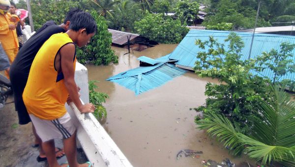 Residents stand on a bridge overlooking their homes submerged in floodwaters during heavy flooding brought by tropical storm Seniang in Misamis Oriental, on Mindanao island in southern Philippines December 29, 2014 Residents stand on a bridge overlooking their homes submerged in floodwaters during heavy flooding brought by tropical storm Seniang in Misamis Oriental, on Mindanao island in southern Philippines December 29, 2014 - Sputnik International
