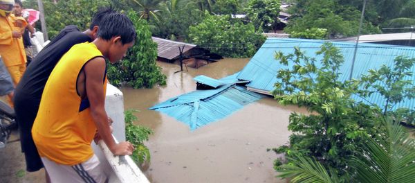 Residents stand on a bridge overlooking their homes submerged in floodwaters during heavy flooding brought by tropical storm Seniang in Misamis Oriental, on Mindanao island in southern Philippines December 29, 2014 Residents stand on a bridge overlooking their homes submerged in floodwaters during heavy flooding brought by tropical storm Seniang in Misamis Oriental, on Mindanao island in southern Philippines December 29, 2014 - Sputnik International