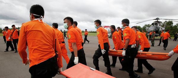 Indonesian Search and Rescue crews walk out to meet a helicopter carrying the bodies of two AirAsia passengers recovered from the sea, at Iskandar airport in Pangkalan Bun, Central Kalimantan, December 31, 2014 Indonesian Search and Rescue crews walk out to meet a helicopter carrying the bodies of two AirAsia passengers recovered from the sea, at Iskandar airport in Pangkalan Bun, Central Kalimantan, December 31, 2014 - Sputnik International