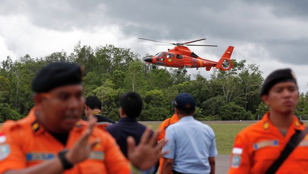 An Indonesian Search and Rescue helicopter carrying the bodies of two AirAsia passengers recovered from the sea prepares to land at the airport in Pangkalan Bun, Central Kalimantan, December 31, 2014 - Sputnik International