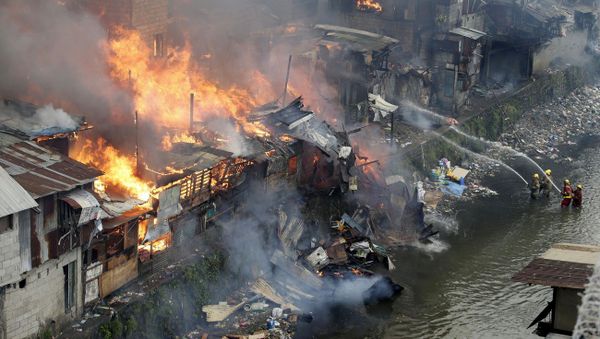 Firefighters fight the fire at shanties from a creek in suburban Quezon city, north of Manila, Philippines during an early morning fire Thursday, Jan. 1, 2015 Firefighters fight the fire at shanties from a creek in suburban Quezon city, north of Manila, Philippines during an early morning fire Thursday, Jan. 1, 2015 - Sputnik International