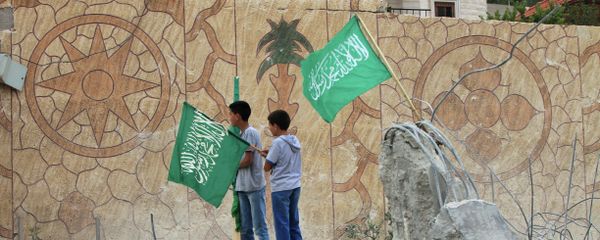 Palestinians raise Islamist Hamas movement flags on the top of what remains of the house of Hussam Qawasmeh Palestinians raise Islamist Hamas movement flags on the top of what remains of the house of Hussam Qawasmeh - Sputnik International