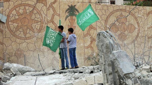 Palestinians raise Islamist Hamas movement flags on the top of what remains of the house of Hussam Qawasmeh Palestinians raise Islamist Hamas movement flags on the top of what remains of the house of Hussam Qawasmeh - Sputnik International