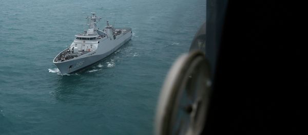 Indonesian navy ship KRI Sultan Hasanudin is seen through the window of a Super Puma helicopter during a search operation for passengers onboard AirAsia Flight QZ8501, off the Java sea, in Indonesia January 7, 2015 - Sputnik International