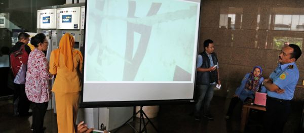 Officer of the National Search And Rescue Agency (BASARNAS) examines an underwater photo of the part of the wreckage of AirAsia. - Sputnik International