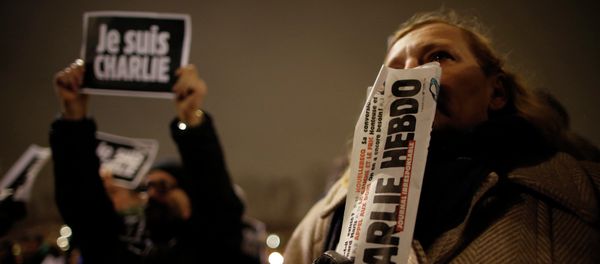 A man holds a copy of weekly satirical magazine Charlie Hebdo to pay tribute during a gathering at the Place de la Republique in Paris A man holds a copy of weekly satirical magazine Charlie Hebdo to pay tribute during a gathering at the Place de la Republique in Paris - Sputnik International