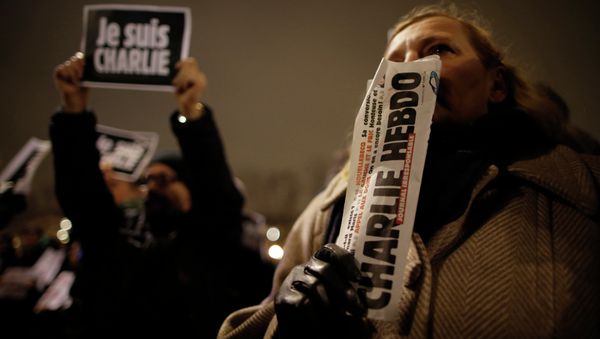 A man holds a copy of weekly satirical magazine Charlie Hebdo to pay tribute during a gathering at the Place de la Republique in Paris A man holds a copy of weekly satirical magazine Charlie Hebdo to pay tribute during a gathering at the Place de la Republique in Paris - Sputnik International