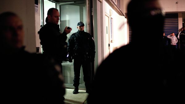 Police officers stand guard in front of a building where forensic police officers look for evidence relating to the three suspects of the shooting attack at the satirical French newspaper Charlie Hebdo's headquarters in Paris - Sputnik International