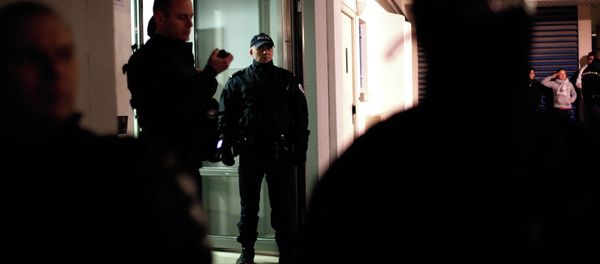 Police officers stand guard in front of a building where forensic police officers look for evidence relating to the three suspects of the shooting attack at the satirical French newspaper Charlie Hebdo's headquarters in Paris Police officers stand guard in front of a building where forensic police officers look for evidence relating to the three suspects of the shooting attack at the satirical French newspaper Charlie Hebdo's headquarters in Paris - Sputnik International