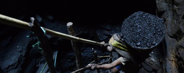 A miner slowly carries a heavy load of wet coal A miner slowly carries a heavy load of wet coal - Sputnik International