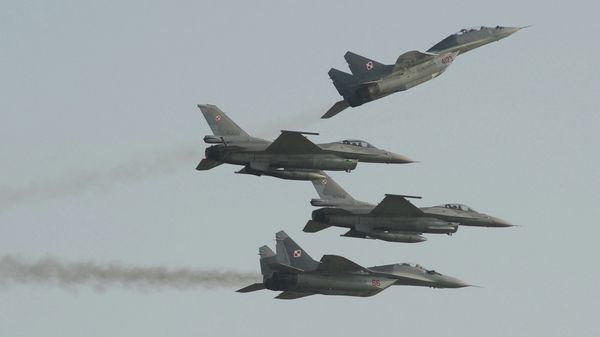 Two Polish Air Force Russian made Mig 29's fly above and below two Polish Air Force U.S. made F-16's fighter jets during the Air Show in Radom, Poland, Saturday, Aug. 27, 2011 - Sputnik International
