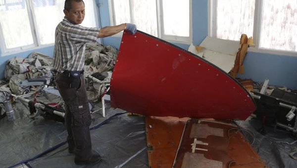A member of Indonesian Search and Rescue Agency holds a piece which Indonesian Air Force confirmed as from AirAsia Flight 8501, at Disaster Victim Identification room in Pangkalan Bun, Indonesia, Friday, Jan. 9, 2015 A member of Indonesian Search and Rescue Agency holds a piece which Indonesian Air Force confirmed as from AirAsia Flight 8501, at Disaster Victim Identification room in Pangkalan Bun, Indonesia, Friday, Jan. 9, 2015 - Sputnik International
