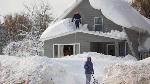 A man clears snow from his roof in the town of Cheektowaga near Buffalo, New York, November 19, 2014 A man clears snow from his roof in the town of Cheektowaga near Buffalo, New York, November 19, 2014 - Sputnik International