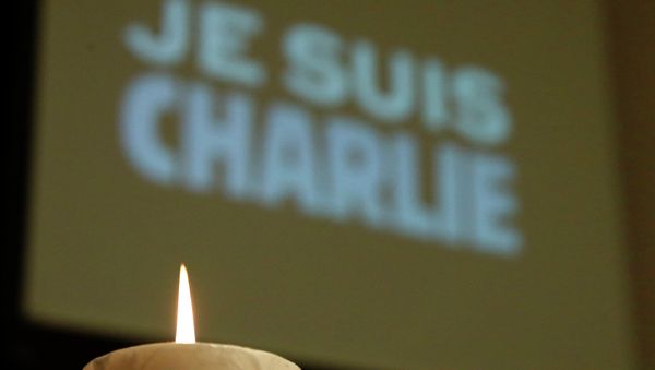 A candle is pictured in front of a Je suis Charlie (I am Charlie) sign A candle is pictured in front of a Je suis Charlie (I am Charlie) sign - Sputnik International