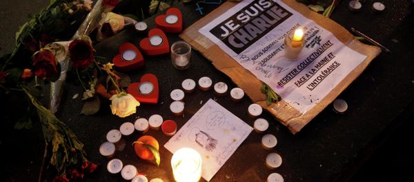 Candles form a heart, near a placard with the message, I am Charlie as people continue to pay tribute to the shooting victims on Wednesday at the satirical weekly Charlie Hebdo, at the Republique square in Paris Candles form a heart, near a placard with the message, I am Charlie as people continue to pay tribute to the shooting victims on Wednesday at the satirical weekly Charlie Hebdo, at the Republique square in Paris - Sputnik International