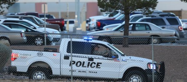 A Fort Bliss Military Police vehicle drives along the perimeter of the El Paso VA parking lot as officers searched for a gunman following a shooting inside the facility Tuesday, Jan. 6, 2014. - Sputnik International