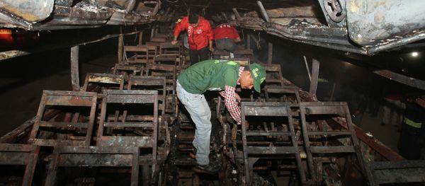 Pakistani rescue workers search through the wreckage of a passenger bus destroyed after colliding with an oil tanker on a highway near Karachi, Pakistan, early Sunday, Jan. 11, 2015. - Sputnik International