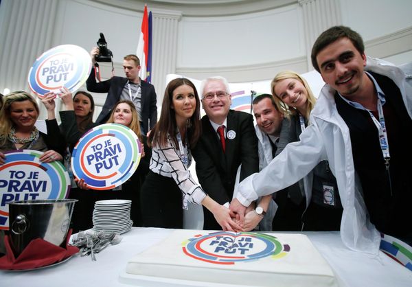 Croatian president and presidential candidate Ivo Josipovic (C) cuts a cake with his supporters after the unofficial results in the headquarters in Zagreb Croatian president and presidential candidate Ivo Josipovic (C) cuts a cake with his supporters after the unofficial results in the headquarters in Zagreb - Sputnik International