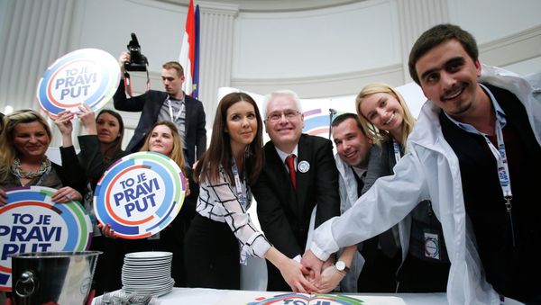 Croatian president and presidential candidate Ivo Josipovic (C) cuts a cake with his supporters after the unofficial results in the headquarters in Zagreb - Sputnik International