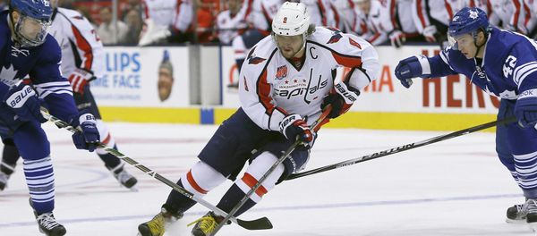 Washington Capitals forward Alex Ovechkin (8) carries the puck past Toronto Maple Leafs forward James van Riemsdyk (left) and forward Tyler Bozak (right) during the first period at the Air Canada Centre. - Sputnik International