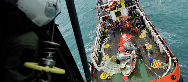 The tail of AirAsia QZ8501 passenger plane is seen on the deck of the rescue ship Crest Onyx from an Indonesian Super Puma military helicopter after it was lifted from the sea bed, south of Pangkalan Bun, Central Kalimantan The tail of AirAsia QZ8501 passenger plane is seen on the deck of the rescue ship Crest Onyx from an Indonesian Super Puma military helicopter after it was lifted from the sea bed, south of Pangkalan Bun, Central Kalimantan - Sputnik International