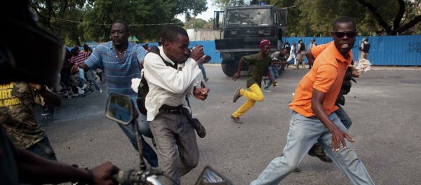 Demonstrators run during a protest demanding the resignation of President Michel Martelly in Port-au-Prince Demonstrators run during a protest demanding the resignation of President Michel Martelly in Port-au-Prince - Sputnik International