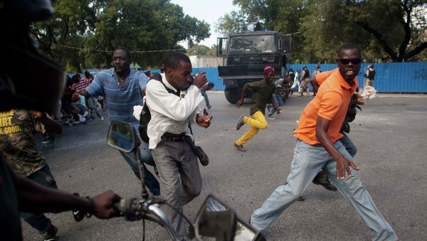 Demonstrators run during a protest demanding the resignation of President Michel Martelly in Port-au-Prince Demonstrators run during a protest demanding the resignation of President Michel Martelly in Port-au-Prince - Sputnik International