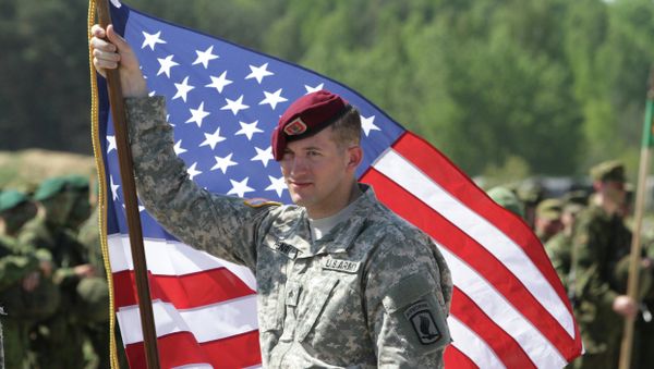 A paratrooper of the 173rd Airborne Brigade of the US Army in Europe holds his country's flag after the final operation of the exercise Black Arrow 2014 in Rukla, Lithuania A paratrooper of the 173rd Airborne Brigade of the US Army in Europe holds his country's flag after the final operation of the exercise Black Arrow 2014 in Rukla, Lithuania - Sputnik International