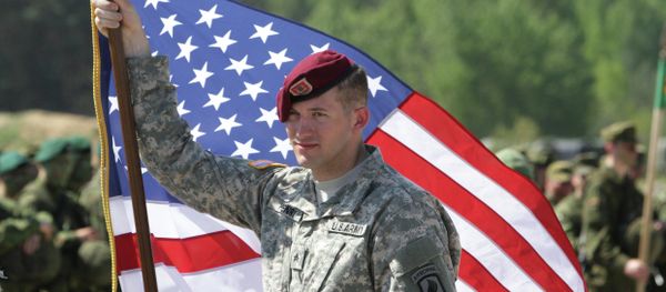 A paratrooper of the 173rd Airborne Brigade of the US Army in Europe holds his country's flag after the final operation of the exercise Black Arrow 2014 in Rukla, Lithuania A paratrooper of the 173rd Airborne Brigade of the US Army in Europe holds his country's flag after the final operation of the exercise Black Arrow 2014 in Rukla, Lithuania - Sputnik International