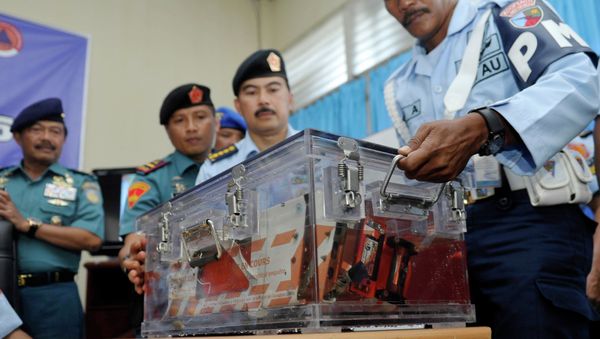 Indonesian military policemen carry the flight data recorder from AirAsia QZ8501 into a media briefing at the airbase in Pangkalan Bun, Central Kalimantan - Sputnik International