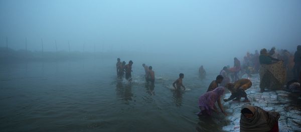 Indian Hindu devotees take a holy dip for the Makar Sankranti festival during the annual Magh Mela gathering at Sangam, the confluence of the rivers Ganges, Yamuna and the mythical Saraswati, during a cold and foggy morning in Allahabad on January 14, 2015 - Sputnik International