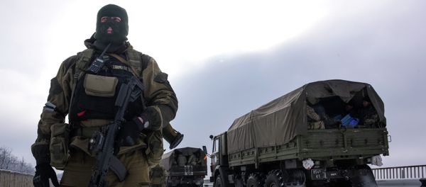 A soldier guards the road near the airport of Donetsk, with Ukrainian military vehicles at rear, Eastern Ukraine, Tuesday, Jan. 6, 2015 - Sputnik International