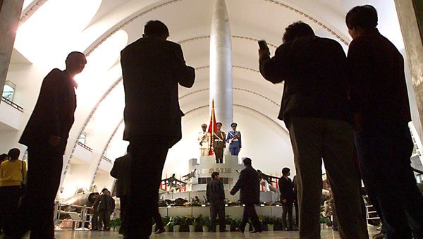 Beijingers pose for pictures in front of one of China's first nuclear missiles, the Dong Feng 1, as they visit the Military Museum 03 November 1999, which showcases the country's military achievements and weapons - Sputnik International