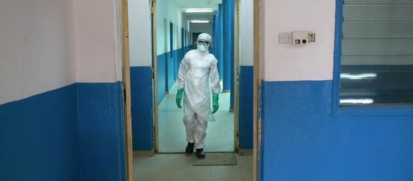 A health worker in protective gear walks inside a Red Cross facility in the town of Koidu, Kono district in Eastern Sierra Leone December 19, 2014 - Sputnik International