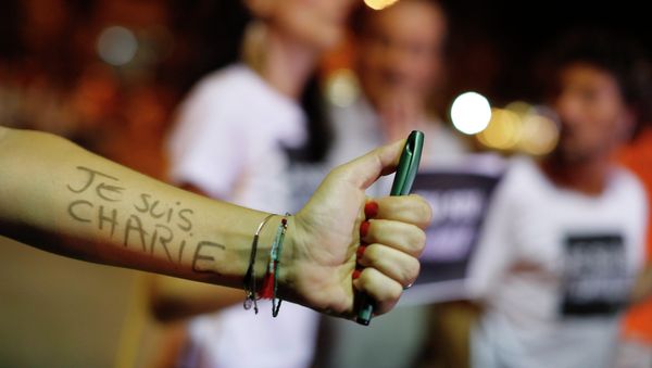 A woman holding a pen shows her arm covered with the words in French I am Charlie at a gathering in solidarity with those killed in an attack at the Paris offices of the weekly newspaper Charlie Hebdo, in a plaza in Rio de Janeiro, Wednesday, Jan. 7, 2015 - Sputnik International