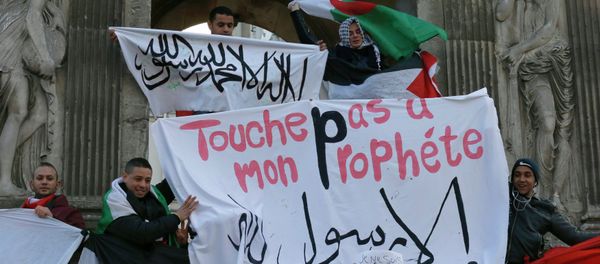 French Muslim youths hold a Islamic flag (top) and a banner reading Do not touch my prophet, anything but the Messenger of Allah as they gather in central Paris January 18, 2015 French Muslim youths hold a Islamic flag (top) and a banner reading Do not touch my prophet, anything but the Messenger of Allah as they gather in central Paris January 18, 2015 - Sputnik International