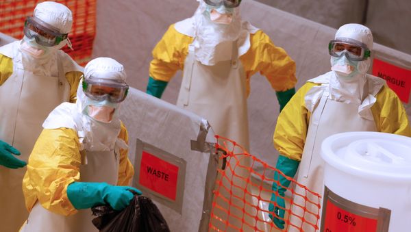 Medical workers wearing protective suits take part in a training prior to leave to countries affected by the Ebolas virus, in an empty factory warehouse in Amsterdam Medical workers wearing protective suits take part in a training prior to leave to countries affected by the Ebolas virus, in an empty factory warehouse in Amsterdam - Sputnik International